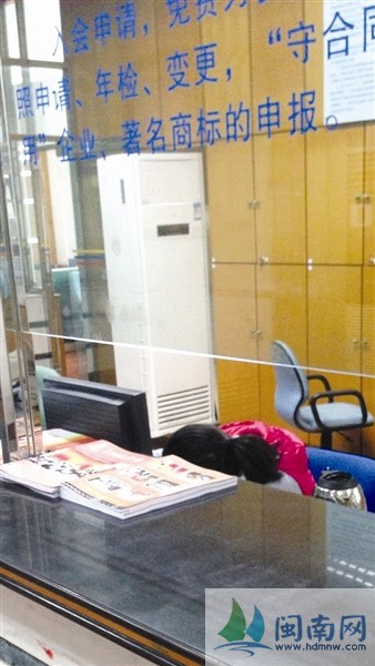 这名窗口办事人员趴在桌上(图片来源于微博)
