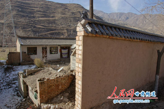 甘肃漳县殪虎桥乡东桥村的“遮羞墙”挡住农户房屋（人民网记者 高翔 张鹏 隋欣 摄）