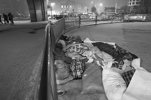 农民工露宿地的不远处，夜幕下车来车往