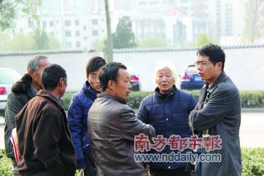 登封法院外,张海超与病人和家属交谈。在许多尘肺病友看来,张海超是一个大救星。