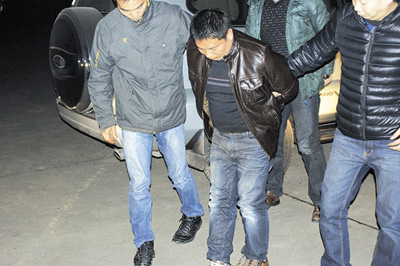 图为:凶手被民警押回宜昌 图为:凶手被民警押回宜昌