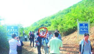 被困女子（圈中）获救后从山岭入口处竖有“军事禁区”的标牌旁通过。