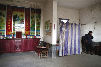 闵拥军家是一栋二层小楼，父母住在帘子后面的地方。