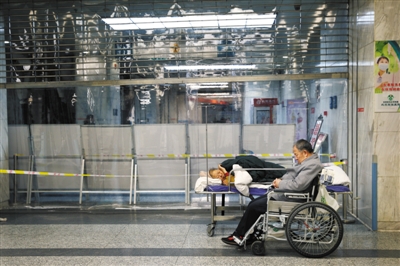 12月20日凌晨,一家医院急诊大厅,一位病人的病床设在急诊分诊台附近。