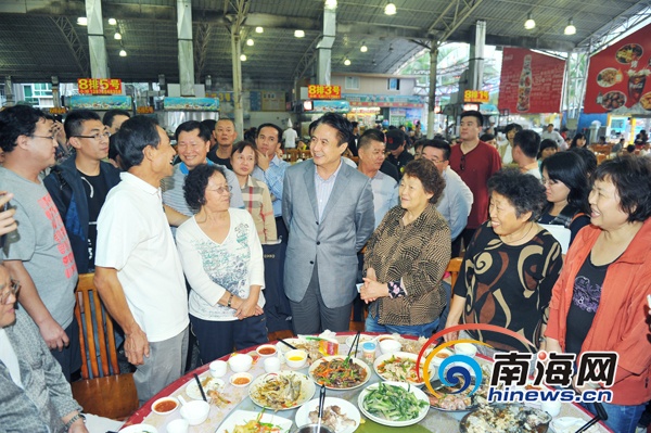 1月1日傍晚，罗保铭乘坐出租车到春园海鲜广场。走进熙熙攘攘的海鲜排挡，罗保铭主动和正在用餐的客人攀谈。(南海网记者秦彦摄)