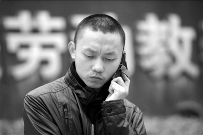 任建宇在劳教所门口接受电话采访(资料图片)。本报记者徐晓帆摄