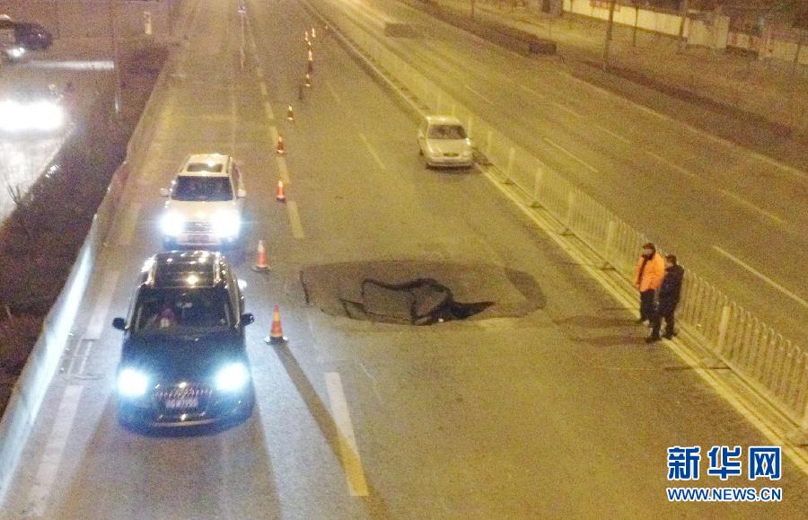 2月8日晚，北京马家堡西路发生一处路面塌陷，形成深度约1.5米，直径大约4米的大坑。事故造成两辆轿车受损。目前，北京市政路桥养护管理集团的工程人员正在抓紧抢修。新华社记者姚大伟摄