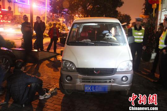 众人抬车救人。 林增崇 摄