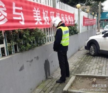 交通协警街边小便被拍照 头顶环境宣传横幅