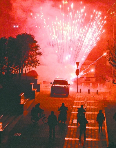 左图:昨晚8点09分,在武昌徐东大街东段的湖北银行门前,有人大肆燃放烟花爆竹,不少行人望而却步。 记者金思柳 摄