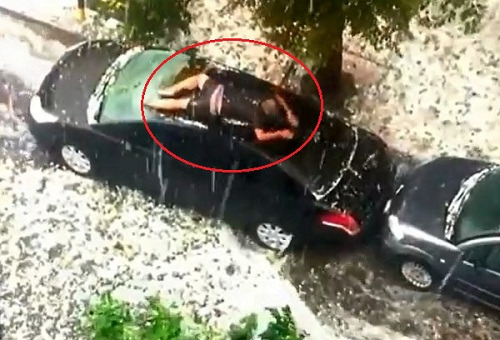 男子为车挡冰雹