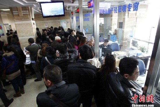 3月3日，上海二手房交易中心，窗口前排队的交易者。3月1日，“新国五条”细则发布，其中明确二手房交易中的个人所得税将会按照个人所得的20%征收。受此影响，中新社发 汤彦俊 摄