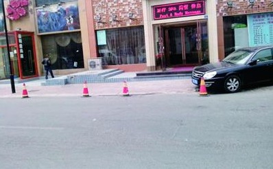 商户占人行道当自家停车场 外人停车威胁扎胎