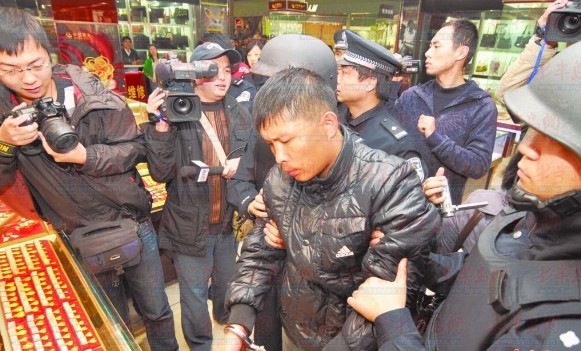 2011年11月21日,嫌犯张某某到城阳区春阳路大润发超市指认现场。记者 徐新东 摄(资料照片) 2011年11月21日,嫌犯张某某到城阳区春阳路大润发超市指认现场。记者 徐新东 摄(资料照片)