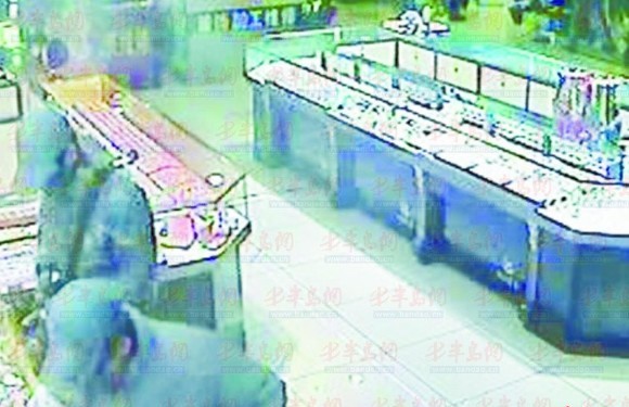 劫匪进店开始打劫(监控画面)。 劫匪进店开始打劫(监控画面)。