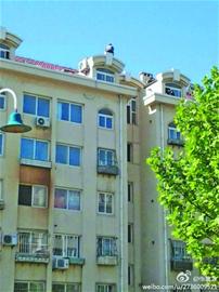 男子浮山后居民楼顶闹悬 就为500元药费