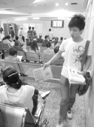 发报人员正在候诊大厅散发虚假宣传品。 本报记者 杨晋峰 摄