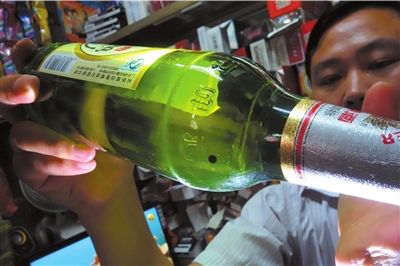 这瓶未开封的燕京啤酒内有一颗黑色悬浮物。京华时报记者 徐晓帆 摄