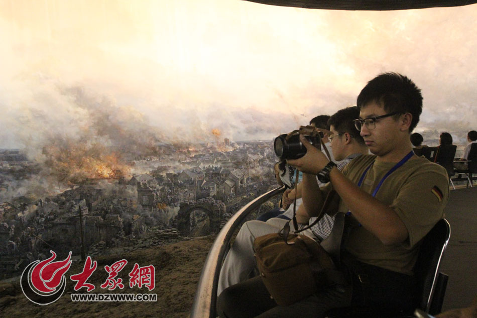 在参观完菏泽市博物馆后，西线采访团来到菏泽冀鲁豫边区革命纪念馆采访。图为记者们在观看模拟战争场面。