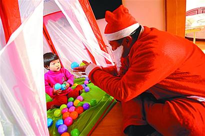 青岛现百名圣诞老人 上门送礼物 惊呆男娃