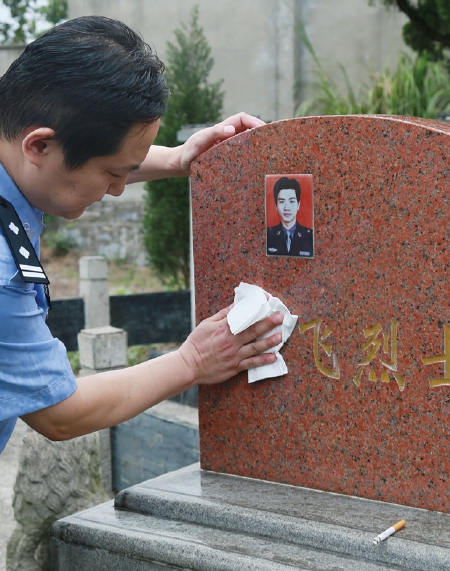 张杰将任飞的墓碑擦拭干净。