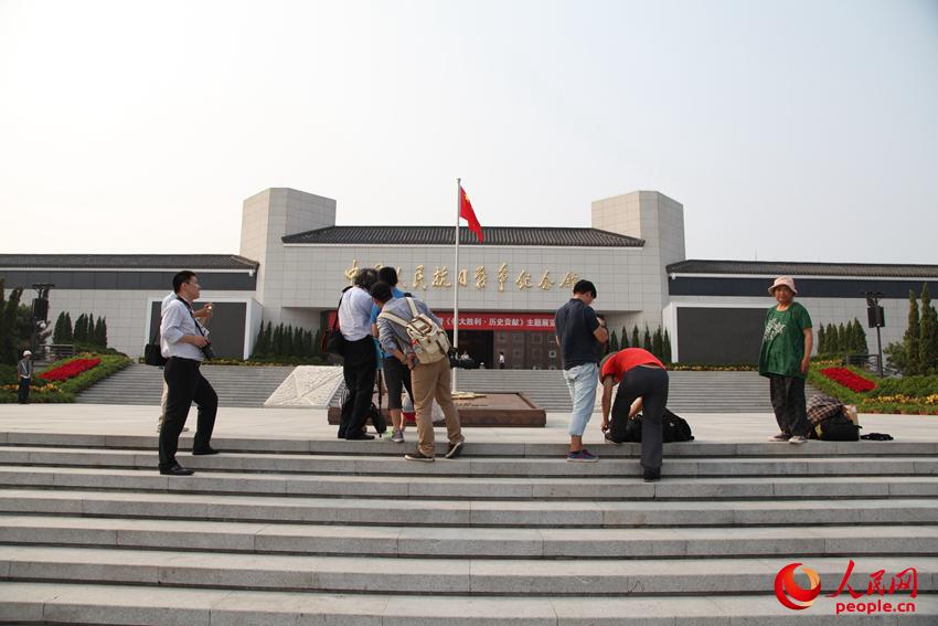 参观展览的观众在纪念馆前拍照留念。邱越摄