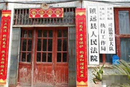 镇远县人民法院的木板门红色的油漆已经脱落了一半。